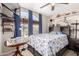 Cozy bedroom with a comfortable bed, large arched window, and a ceiling fan at 8053 E Dover St, Mesa, AZ 85207