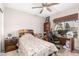 Bright bedroom featuring a ceiling fan, desk, and bed with a soft patterned comforter at 8053 E Dover St, Mesa, AZ 85207