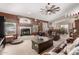 Spacious living room with a fireplace, ceiling fan, plush seating, and bright natural light at 8053 E Dover St, Mesa, AZ 85207
