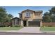 Charming two-story home with a blend of stucco and stone facade, attached garage, and inviting curb appeal at 8323 E Petunia Ave, Mesa, AZ 85212