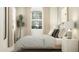 Comfortable bedroom featuring a plush bed, matching nightstands, soft lighting, and large window with natural light at 8323 E Petunia Ave, Mesa, AZ 85212