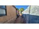 A narrow passageway in the backyard with walls and various items at 8527 W Jefferson St, Peoria, AZ 85345