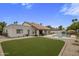 Expansive backyard featuring an artificial turf lawn, large in-ground swimming pool, and lush landscaping at 8648 E San Jacinto Dr, Scottsdale, AZ 85258