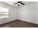 Bright bedroom features wood floors, a ceiling fan, and a window overlooking the neighborhood at 927 E Greenway Rd, Phoenix, AZ 85042