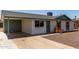 Single-story home featuring a brick accent, gravel landscaping, and a covered carport and driveway at 927 E Greenway Rd, Phoenix, AZ 85042