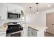 Stylish kitchen with stainless steel appliances, a gas range, and a stone countertop island at 927 E Greenway Rd, Phoenix, AZ 85042