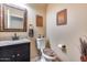 Cozy half bathroom featuring modern sink with granite counter, neutral color scheme, and a wall mirror at 965 E Virgo Pl, Chandler, AZ 85249