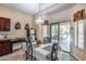 Bright dining area with sliding glass door to patio and pool, modern table set, and breakfast bar at 965 E Virgo Pl, Chandler, AZ 85249