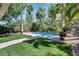 Beautiful backyard pool surrounded by lush tropical landscaping and a green lawn at 965 E Virgo Pl, Chandler, AZ 85249