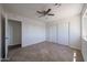 Bright bedroom featuring neutral tile floors, ceiling fan, and a closet with sliding doors at 10002 N 66Th Ln, Glendale, AZ 85302