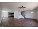 An open-concept living room featuring wood-look flooring, neutral-toned walls, and easy access to the kitchen and staircase at 10002 N 66Th Ln, Glendale, AZ 85302