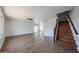 Spacious living room with wood-look flooring, large windows, and an adjacent staircase to the upper level at 10002 N 66Th Ln, Glendale, AZ 85302