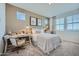 Well-lit bedroom showcasing a cozy bed, an ornate desk, and serene windows with beautiful views at 10107 E Ulysses Ave, Mesa, AZ 85212