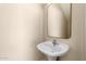 Powder room featuring a pedestal sink and a mirror at 12426 W Adams St, Avondale, AZ 85323