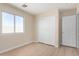 This bedroom has light wood floors, large window, closet and door at 12426 W Adams St, Avondale, AZ 85323