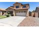 Two-story home featuring a two-car garage, desert landscaping, and a covered front porch at 12426 W Adams St, Avondale, AZ 85323