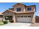 Two-story home featuring a two-car garage, desert landscaping, and a covered front porch at 12426 W Adams St, Avondale, AZ 85323