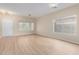 Spacious living room with new laminated wood floors, white walls, and a modern ceiling fan at 12426 W Adams St, Avondale, AZ 85323
