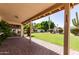 Covered backyard patio with brick pavers and expansive views of the green lawn and cacti at 1258 E Granada St, Mesa, AZ 85203