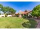 Spacious backyard featuring a well-manicured lawn, mature trees, and a charming patio area with a view of the house at 1258 E Granada St, Mesa, AZ 85203