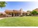 Expansive backyard featuring lush green grass, mature trees, and a charming patio, perfect for outdoor relaxation at 1258 E Granada St, Mesa, AZ 85203