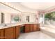 Well-lit bathroom with large vanity, soaking tub, and bright window with garden view at 1258 E Granada St, Mesa, AZ 85203