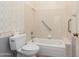 Bathroom with a white toilet, a shower-tub with grab bars and floral wallpaper at 1258 E Granada St, Mesa, AZ 85203