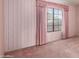 Bedroom with a window, carpeted floors, pink curtains and wallpaper at 1258 E Granada St, Mesa, AZ 85203