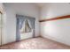 Carpeted bedroom featuring a large window with blue curtains and a wooden trim at 1258 E Granada St, Mesa, AZ 85203