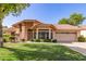 Charming home showcasing a well-maintained lawn, tile roof, mature landscaping, and an attached two-car garage at 1258 E Granada St, Mesa, AZ 85203