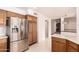Kitchen view featuring stainless steel refrigerator and ample cabinetry with a breakfast bar and view into the living room at 1258 E Granada St, Mesa, AZ 85203