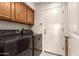 Laundry room featuring a washer, dryer, overhead cabinets and white door at 1258 E Granada St, Mesa, AZ 85203