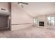 Open-concept living room featuring a fireplace, vaulted ceilings, and a large window offering an abundance of natural light at 1258 E Granada St, Mesa, AZ 85203