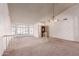 Open-concept living area featuring large windows, a decorative chandelier, and access to front entryway at 1258 E Granada St, Mesa, AZ 85203