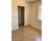 Well-lit bedroom with tile flooring, neutral walls, window, and closet with a sliding door at 13208 N 51St Ln, Glendale, AZ 85304