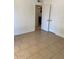Bright bedroom with neutral walls, tile flooring, and double doors leading to another room at 13208 N 51St Ln, Glendale, AZ 85304