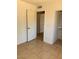 Comfortable bedroom featuring tile floors, light-colored walls, and a closet with an open door at 13208 N 51St Ln, Glendale, AZ 85304