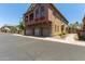 Multi-story home with a three-car garage featuring stone accents and manicured landscaping at 1350 S Greenfield Rd # 2205, Mesa, AZ 85206
