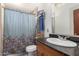 Bathroom with shower curtain, vanity with dark countertop, sink, and decorative towels at 1417 W Rose Ln, Phoenix, AZ 85013