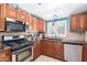 Well-equipped kitchen with stainless steel appliances, custom cabinetry, and tiled backsplash at 1417 W Rose Ln, Phoenix, AZ 85013