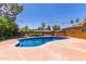 Backyard pool surrounded by a concrete patio and mature landscaping, creating a private oasis at 1417 W Rose Ln, Phoenix, AZ 85013
