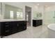 Elegant bathroom with dual vanities, sleek dark cabinets, a large mirror, and pristine white countertops and floors at 14177 W Calle Lejos --, Surprise, AZ 85387