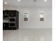 Modern kitchen with stainless steel appliances, dark cabinets, and white tiled floor and two windows at 14177 W Calle Lejos --, Surprise, AZ 85387