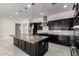 Bright open kitchen with an oversized island, granite counters, dark cabinets, and stainless steel appliances at 14177 W Calle Lejos --, Surprise, AZ 85387