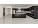 Open kitchen with black cabinetry, stainless appliances, large island, and modern fixtures with tile floor at 14177 W Calle Lejos --, Surprise, AZ 85387