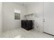 Bright laundry room with modern washer and dryer, plus storage shelves and tile flooring at 14177 W Calle Lejos --, Surprise, AZ 85387