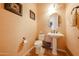 Stylish half bathroom features a modern pedestal sink, decorative wallpaper, and elegant fixtures at 14725 S 182Nd Dr, Goodyear, AZ 85338
