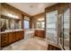 Bathroom with stone tile flooring, dual sink vanity, soaking tub, and walk-in closet at 14725 S 182Nd Dr, Goodyear, AZ 85338