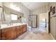 Bathroom with a dual-sink vanity, decorative wallpaper, and a glass-enclosed shower at 14725 S 182Nd Dr, Goodyear, AZ 85338