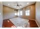 Spacious bedroom with hardwood floors, natural light, a ceiling fan, and a cozy rug at 14725 S 182Nd Dr, Goodyear, AZ 85338